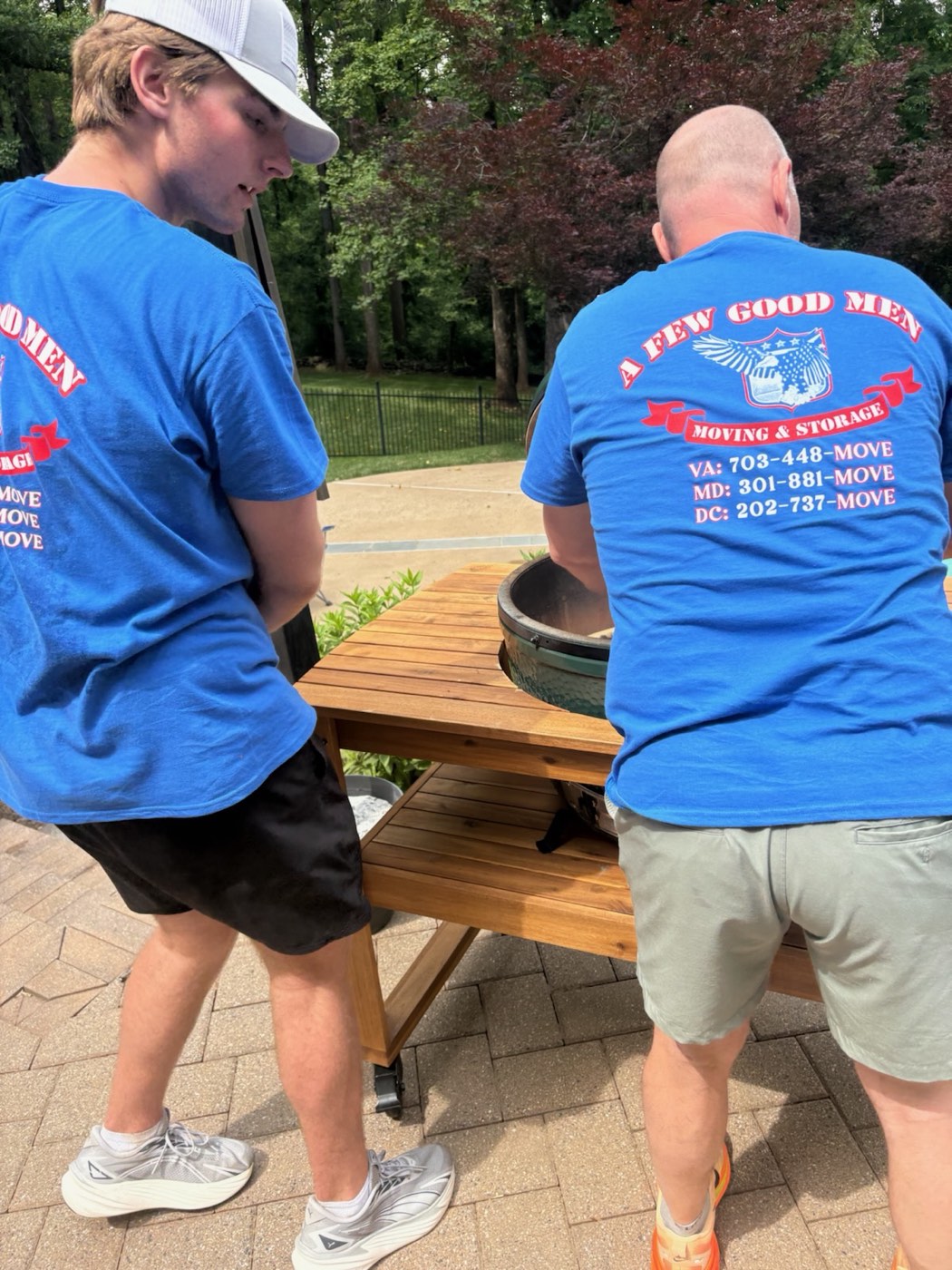 Two A Few Good Men movers in crew shirts working outside a home